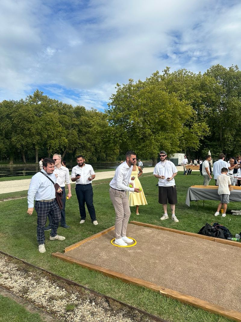 Guests playing pétanque on a sand court on the château lawns.