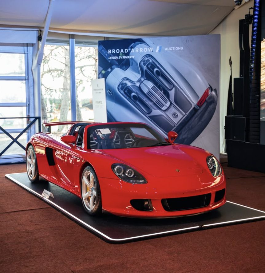 Un Porsche Carrera GT rojo sobre una plataforma de exposición